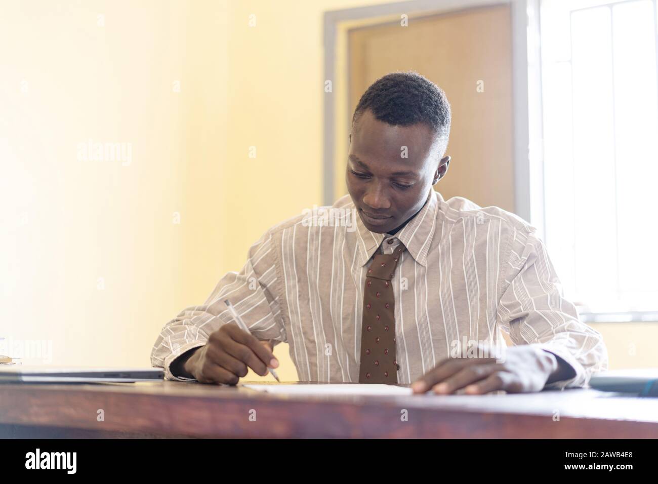 Candid photograph of African black man businessman working person signing a contract making a deal Stock Photo