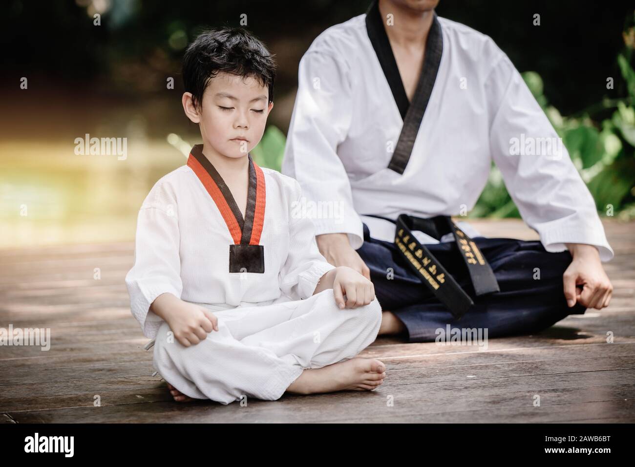 Fighter kid in Taekwondo uniform sitting concentration for training self defense body and mild. Stock Photo