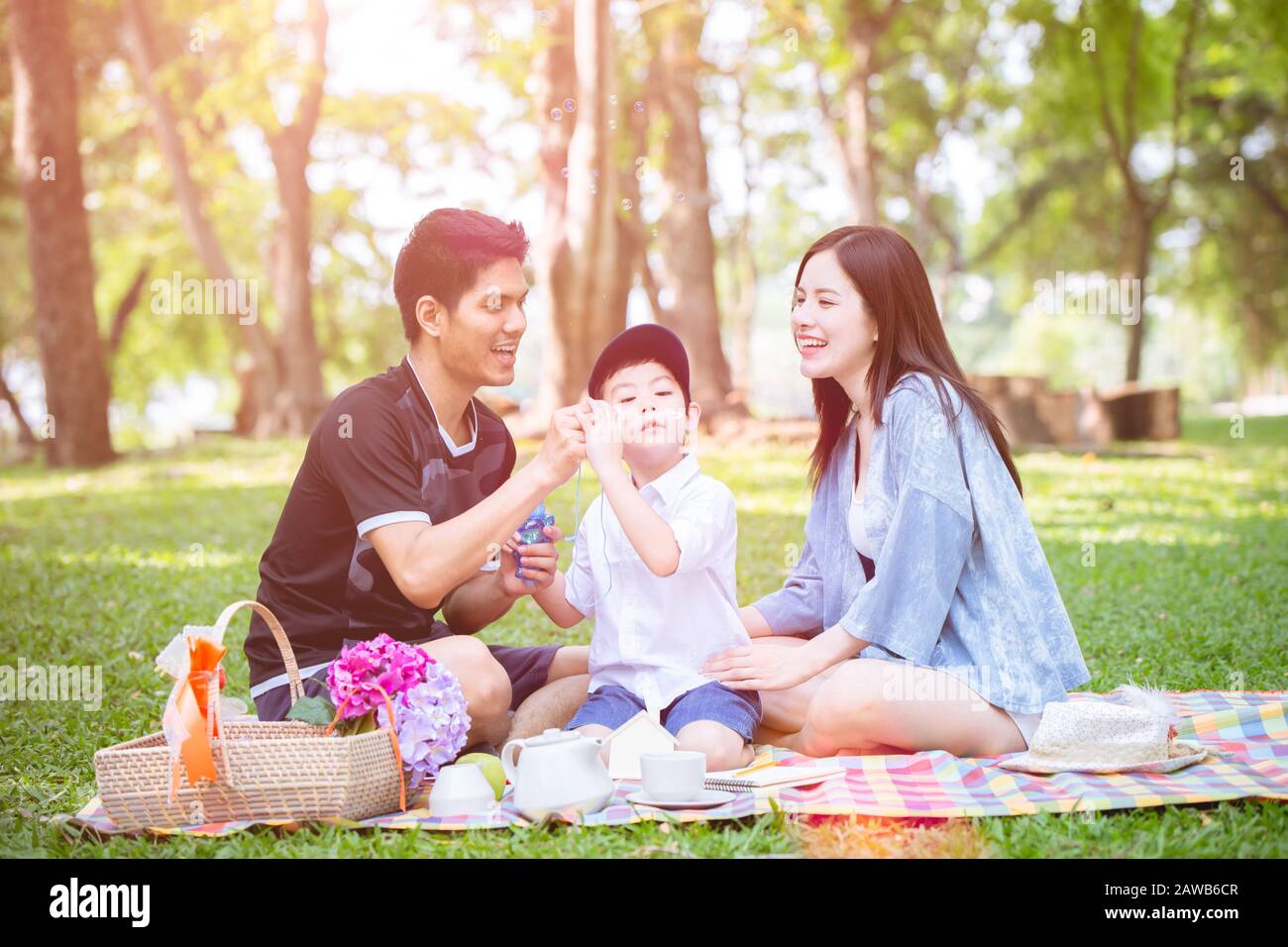 young family playing with child kid outdoor park lovely lifestyle and living with nature Stock Photo