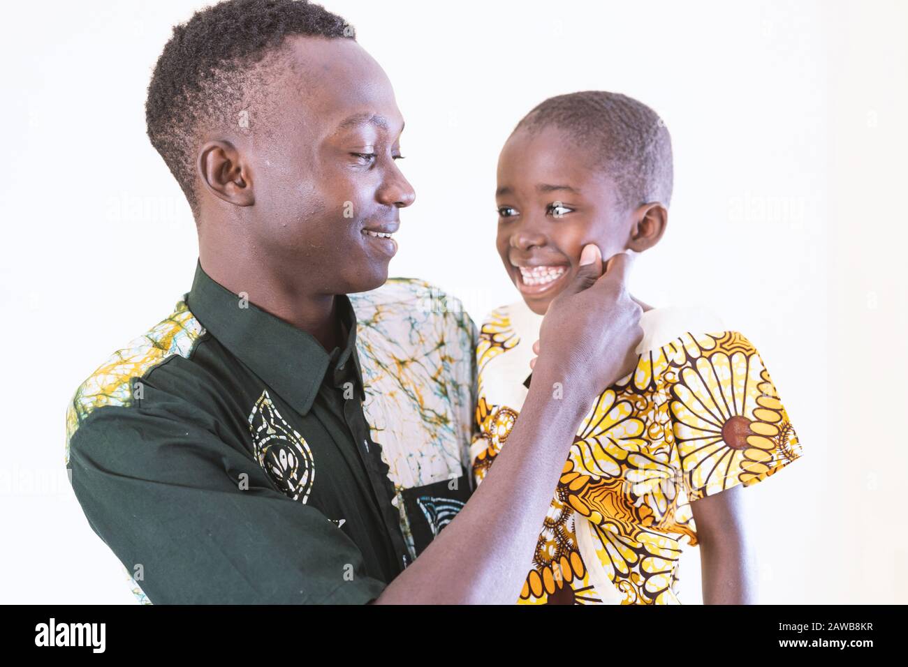 African dad and son posing together in front of camera laughing and smiling in front of white background Stock Photo