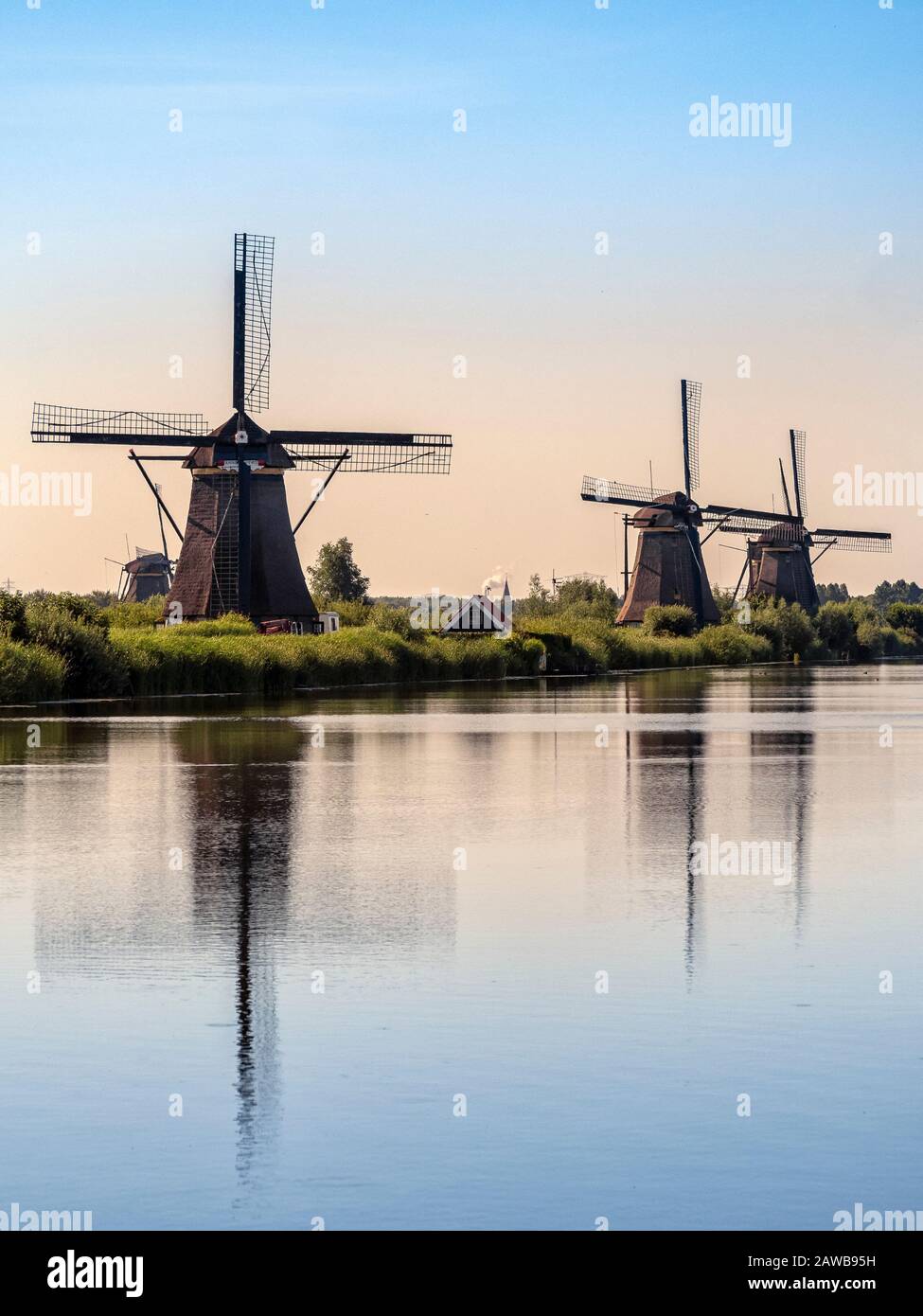 NETHERLANDS - JULY 04, 2019: The historic 17th Century windmills at Kinderdijk in early morning light with reflection in a canal Stock Photo