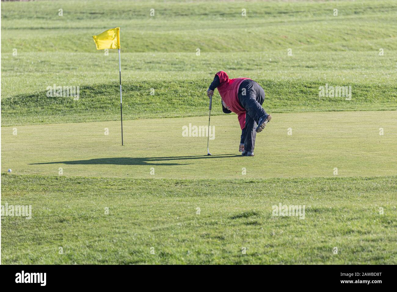A golfer placing his ball on the green. Stock Photo