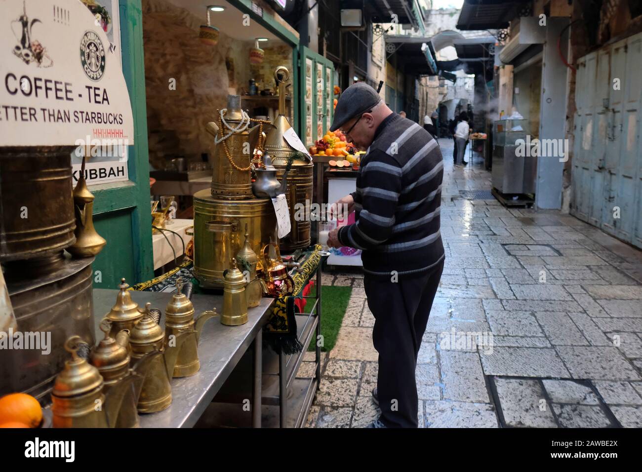 Palestinian man pouring hot Salep, also spelled sahlep or sahlabon in El Wad also called Hagai Street in the old city of Jerusalem. Israel Stock Photo