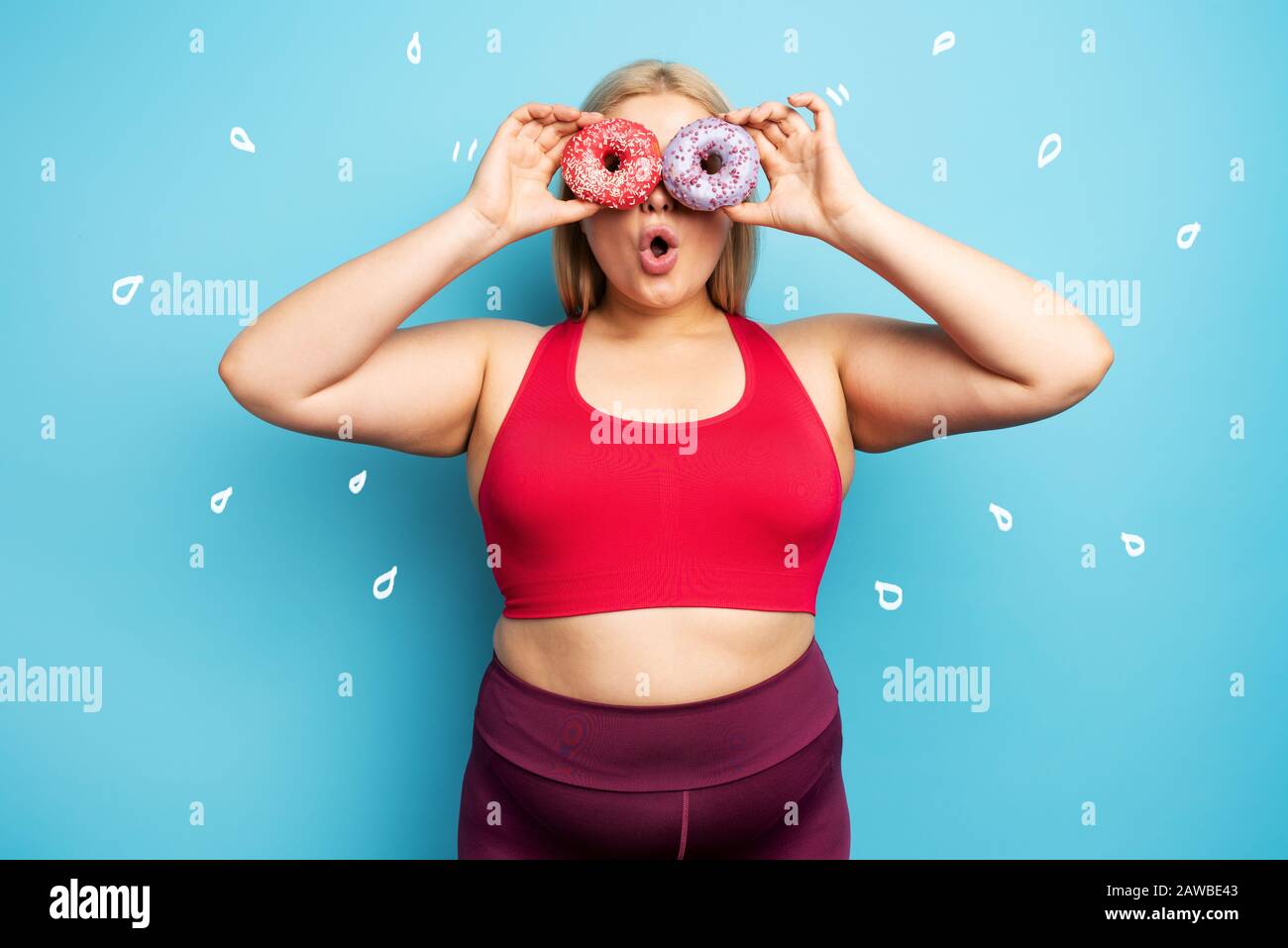 Fat girl thinks to eat donuts instead of does gym. Concept of indecision and doubt Stock Photo