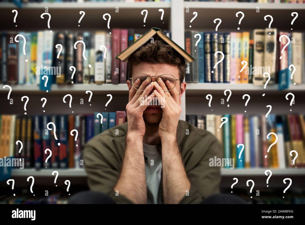 Tired university student has difficulty to study. Full of question mark. Concept of stress and difficulty Stock Photo