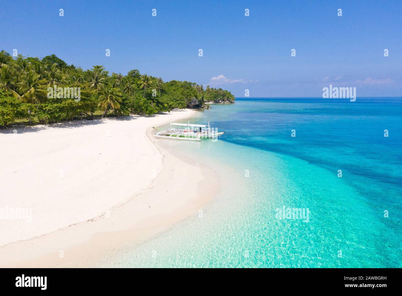 Tropical island with a white beach. Island with palm trees and white sand, top view. Summer and travel vacation concept. Mahaba Island, Philippines. Stock Photo