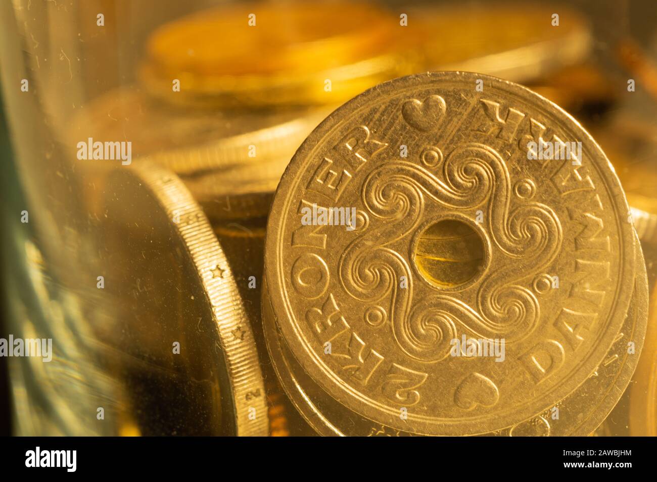 Coins of different countries in a glass jar. a lot of metal coins of different denominations and various countries. financial background. danish krone Stock Photo