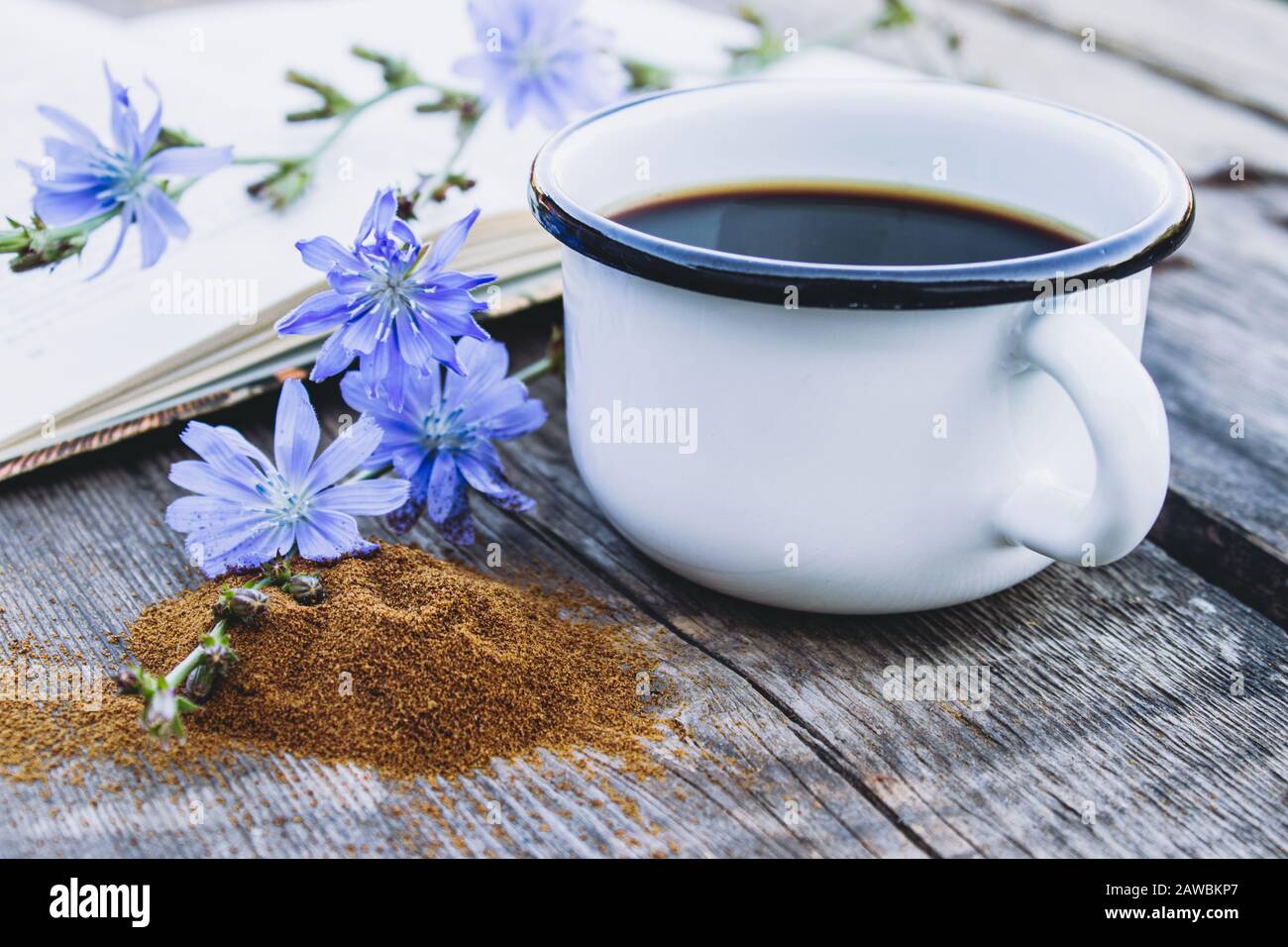White cup with chicory drink and flowers near chicory powder. Tea from ...