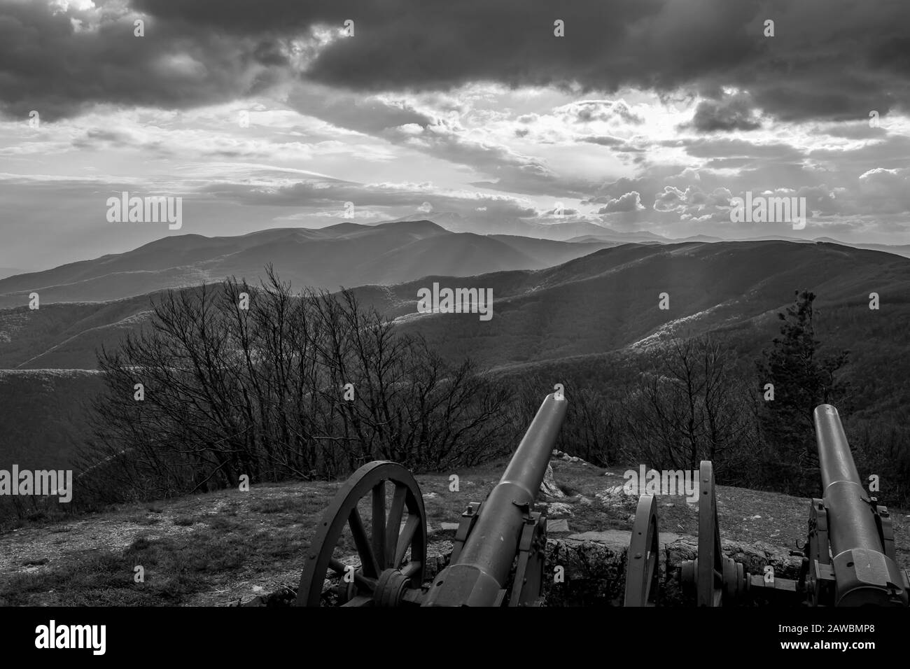 Dramatic autumn black and white view over the mountain range from near Shipka peak, Stara Planina mountain in Central Bulgaria as seen from Shipka Memorial. Moody feeling. Old Russian cannon Stock Photo