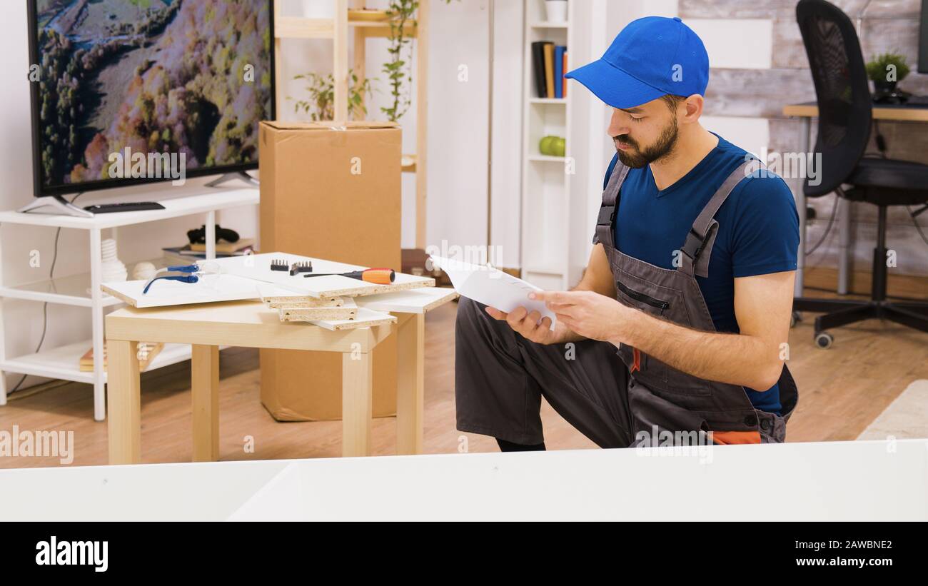 Professional furniture assembly worker checking position of the shelf. Worker follows