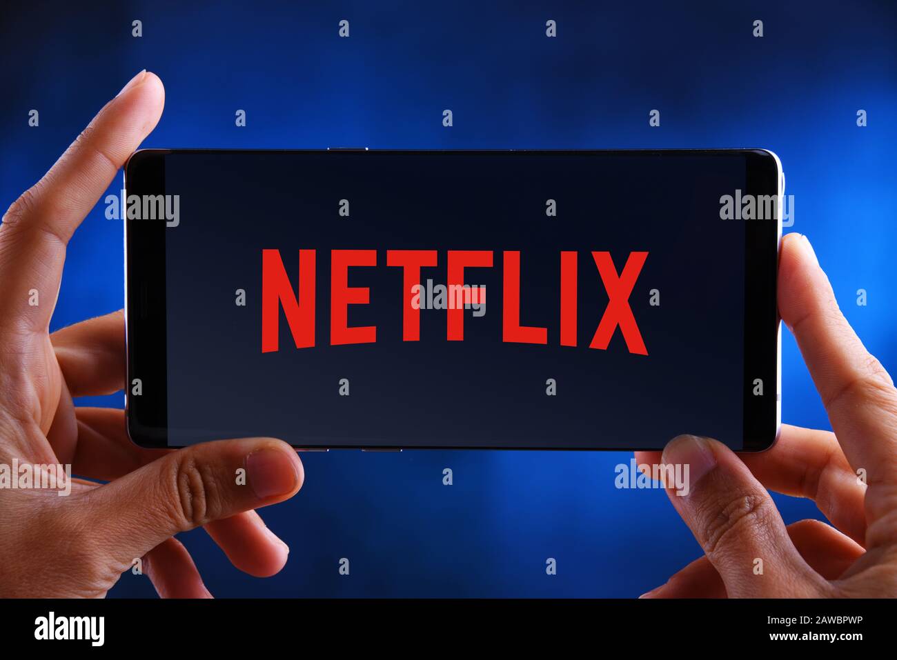 POZNAN, POL - JUL 10, 2019: Hands holding smartphone displaying logo of Netflix, an American media-services provider headquartered in Los Gatos, Calif Stock Photo