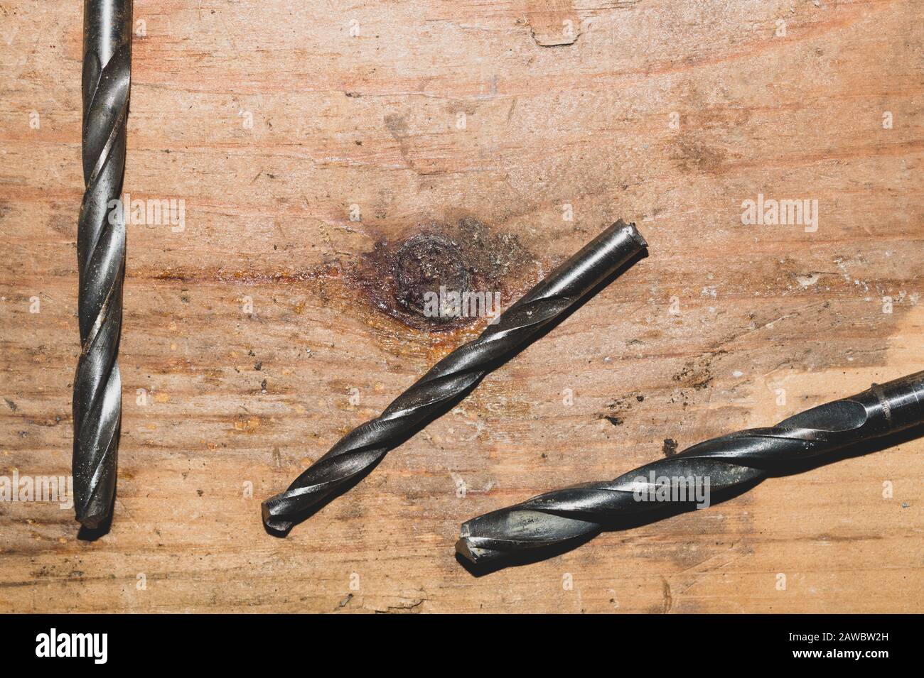 Drills on a wooden table. pile of drill bits on a wood background. work