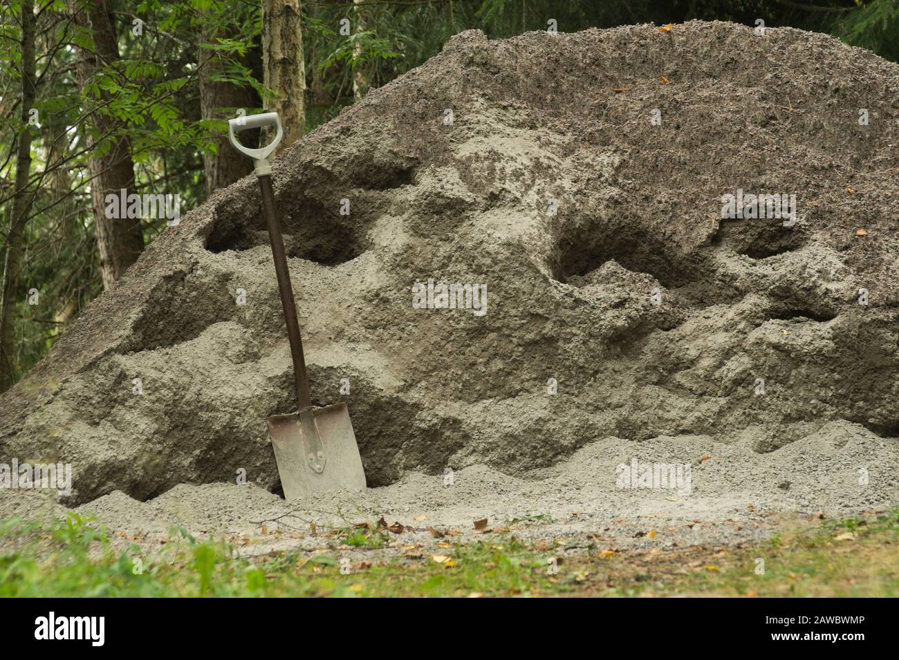 Shovel placed on a sand hill. manual labor background Stock Photo