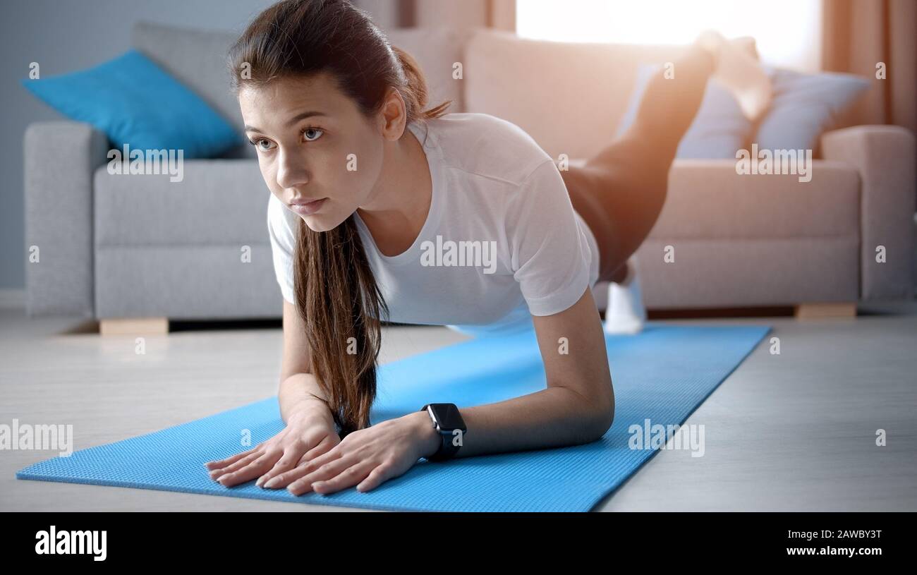 Girl do forearm one-legged plank Stock Photo