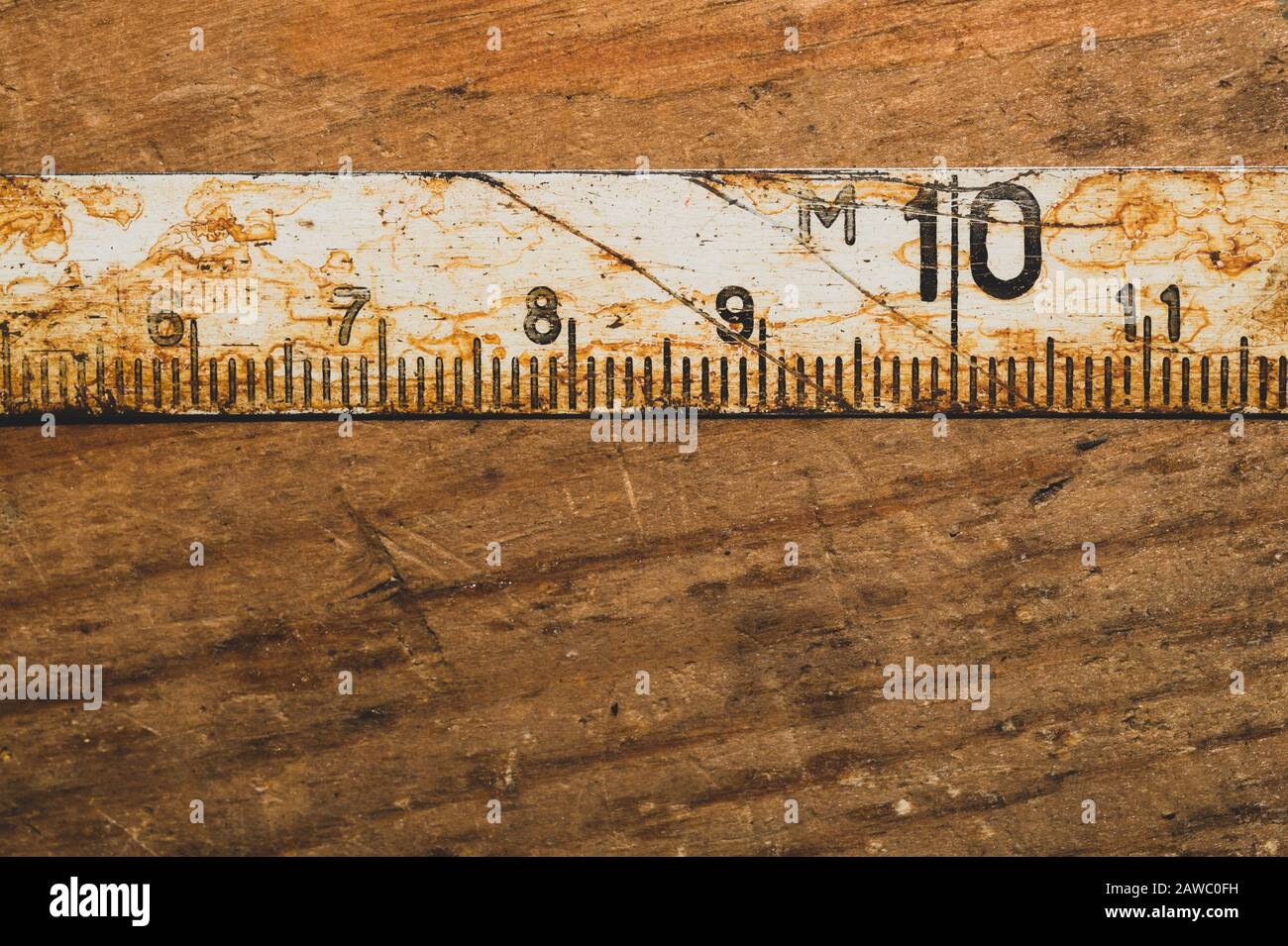 Old rusty ruler with black numbers on a working wooden table. vintage ...