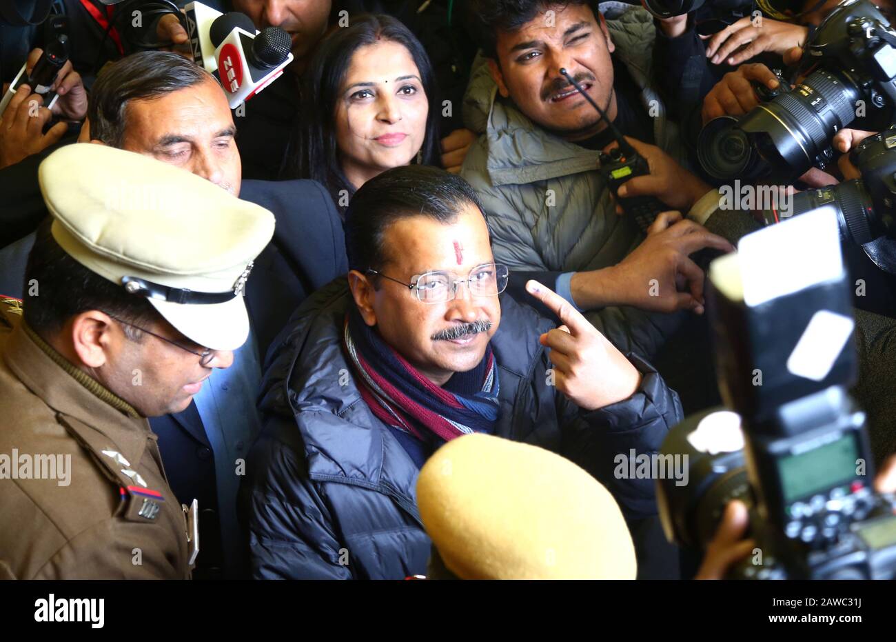 New Delhi, India. 8th Feb, 2020. Delhi Chief Minister Arvind Kejriwal (C) is surrounded by media workers and police personnel as he shows his finger marked with ink after casting his vote in New Delhi, India, Feb. 8, 2020. Voting for the local elections in the Indian capital began Saturday morning amid tight security and adequate arrangements, officials said. Credit: Str/Xinhua/Alamy Live News Stock Photo