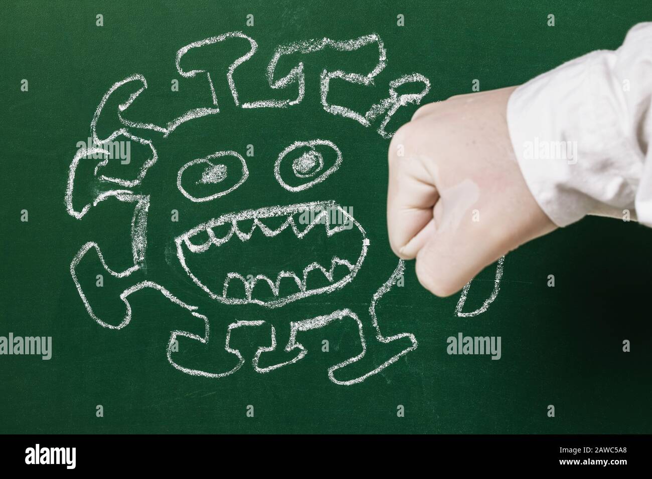 Drawing chalk on the school board and fist. Concept on the theme: Scientists defeat coronavirus 2019-nCoV Stock Photo