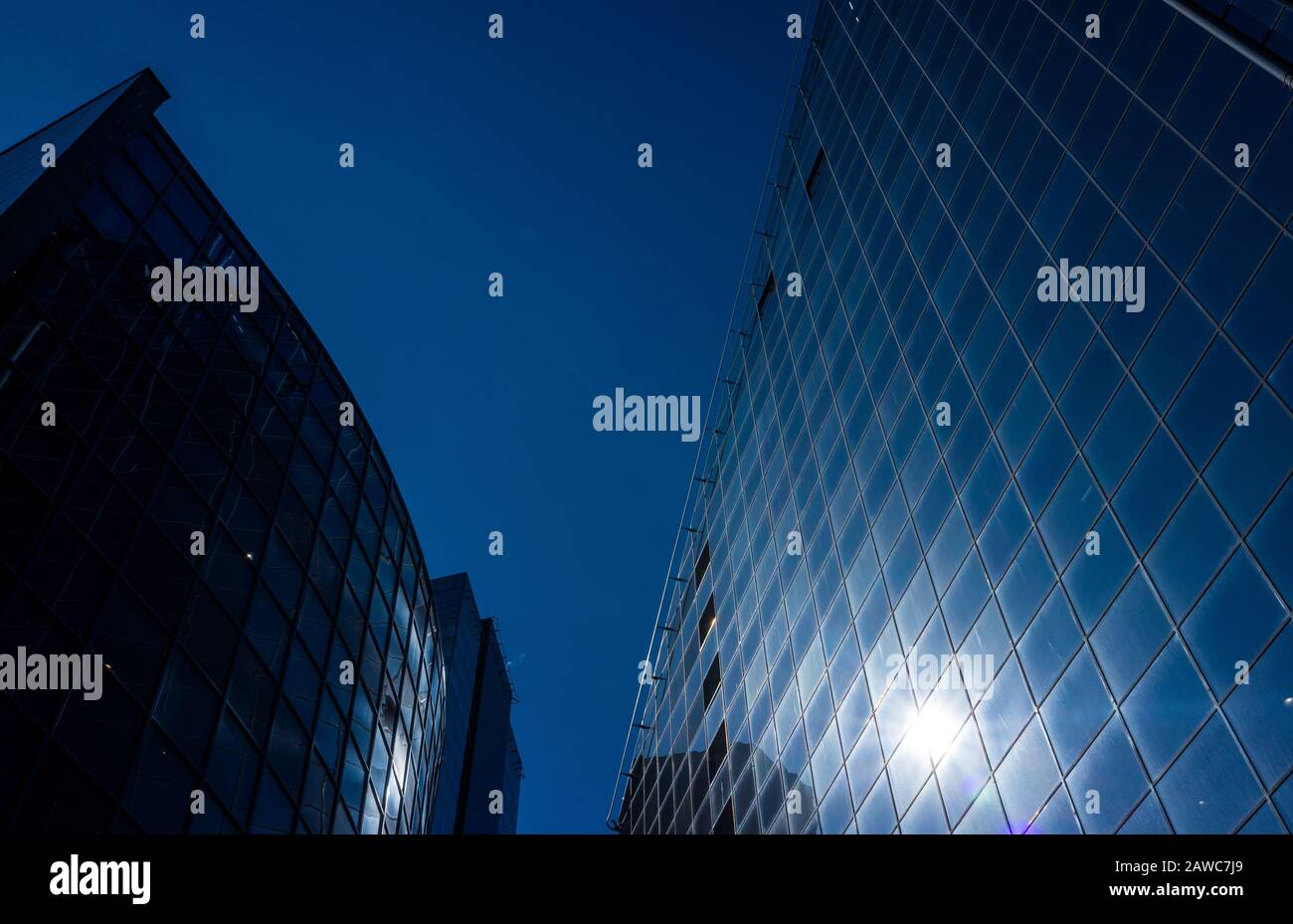 The sun's rays are reflected in the glass of a modern office skyscraper ...