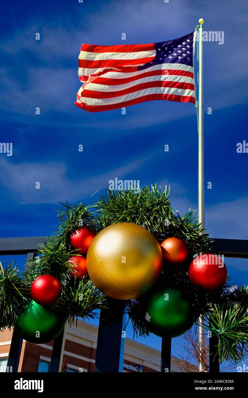 An American Flag flying over Christmas decorations under a blue sky