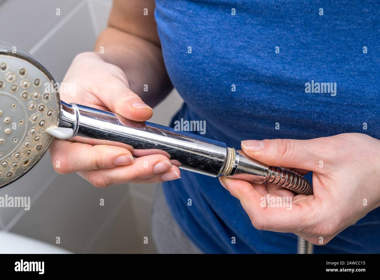https://c8.alamy.com/comp/2AWCC15/woman-is-holding-a-broken-shower-sprinkler-head-in-her-hands-and-changes-to-a-new-one-2AWCC15.jpg