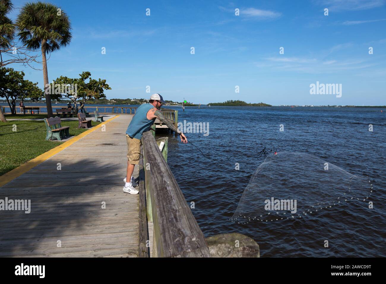 A fisherman casts his net into the Manatee Pocket at Sandsprit Park in Port Salerno, Florida, USA. Stock Photo