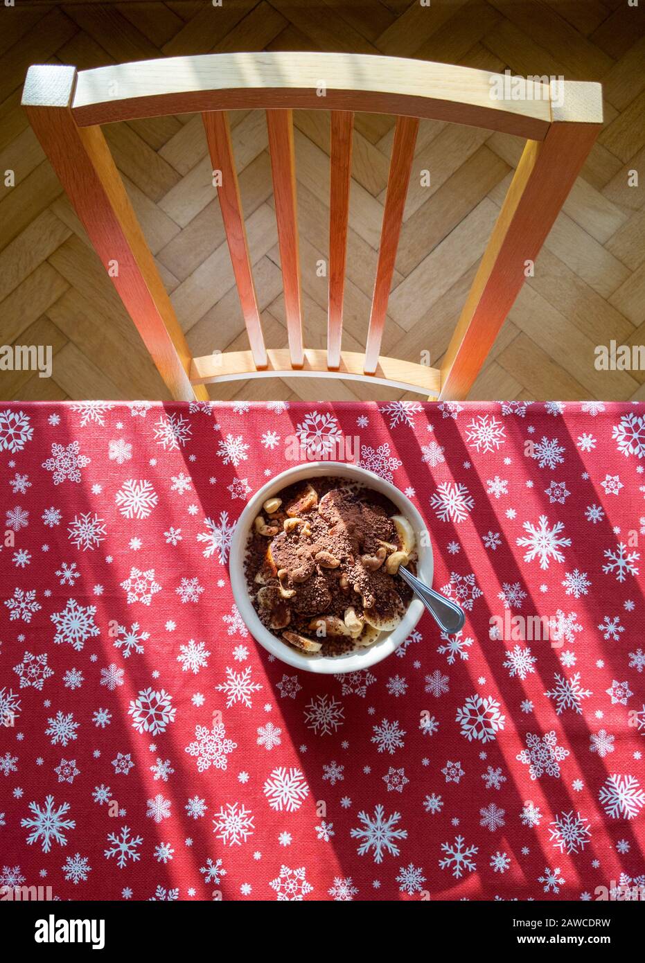 still life - breakfast on the table, red tablecloth with a pattern of snowflakes, chairs at the table - view from above Stock Photo