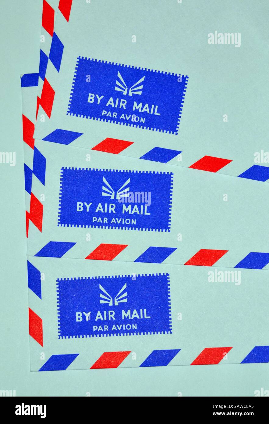 The corners of three air mail envelopes showing the air mail logo of