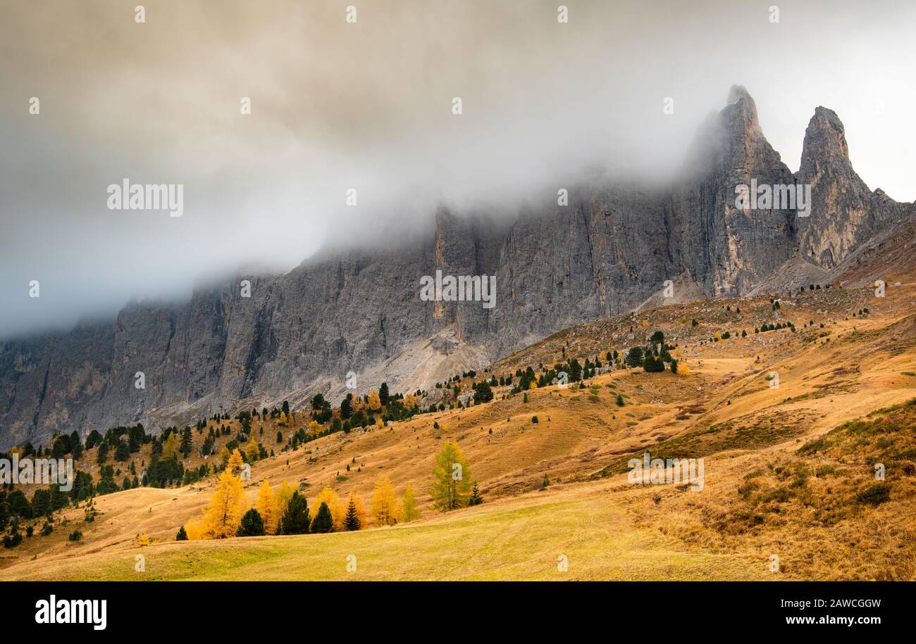 Breathtaking views of the Mountain peaks of Langkofel or Saslonch, mountain range in the dolomites covered with fog during sunrise in , Italy Stock Photo