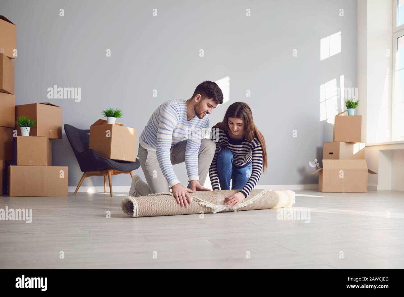 Young couple family with boxes to move in a new house room. Stock Photo