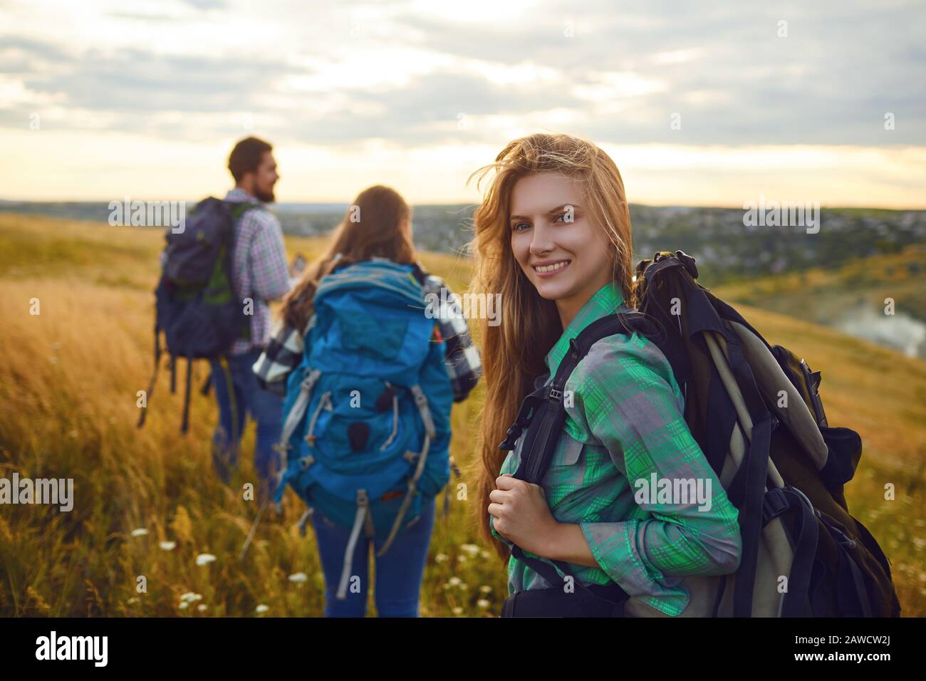 Group of friends trekking with backpacks walking in the forest . Stock Photo