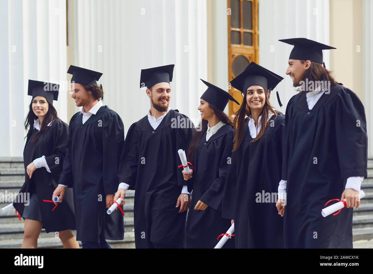 Group of students graduates go against the university college. Stock Photo