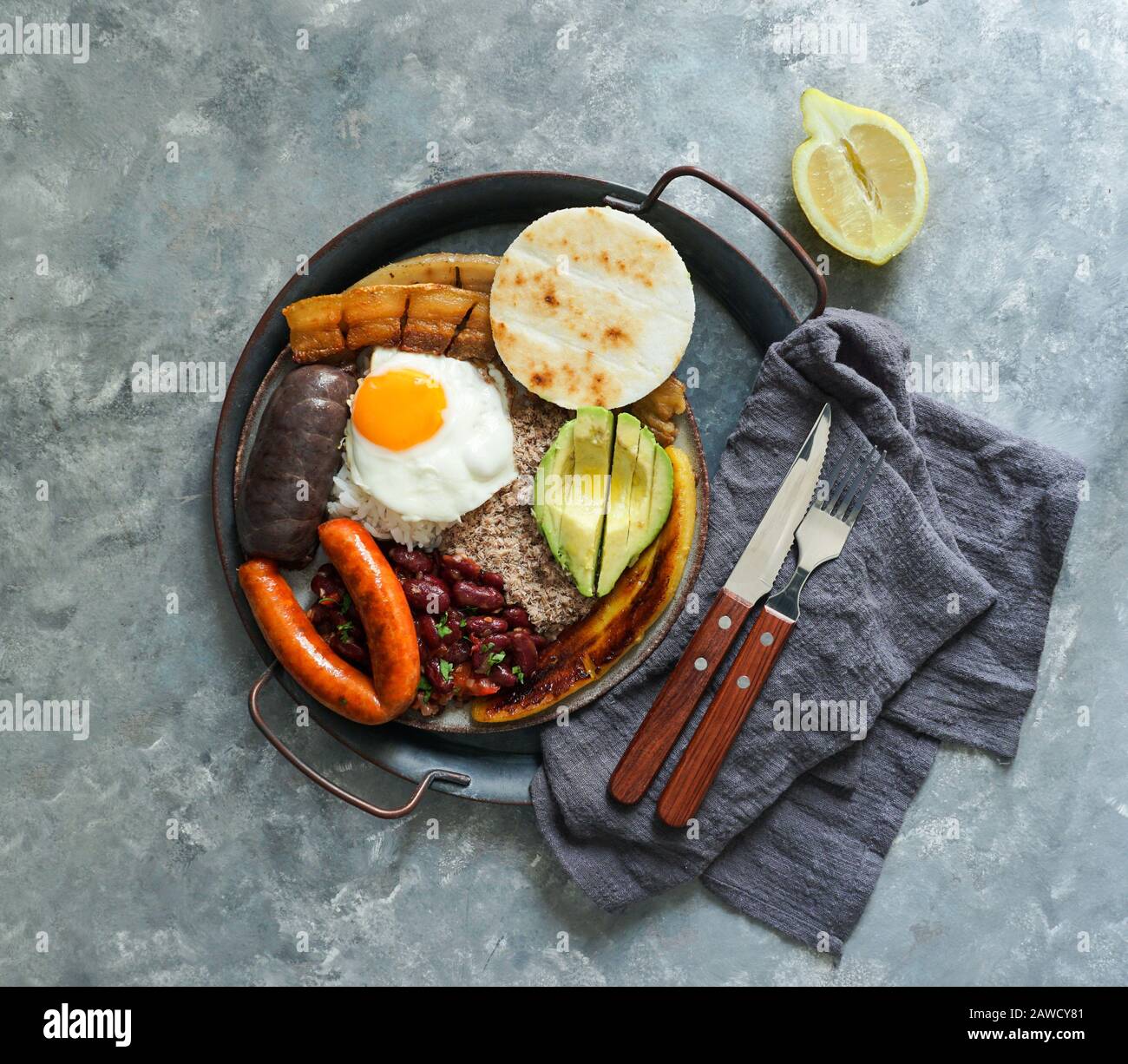 Colombian food. Bandeja paisa, typical dish at the Antioquia region of Colombia - chicharron (fried pork belly), black pudding, sausage, arepa, beans, Stock Photo