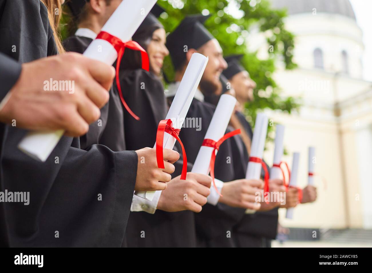 Graduates with diplomas. Stock Photo