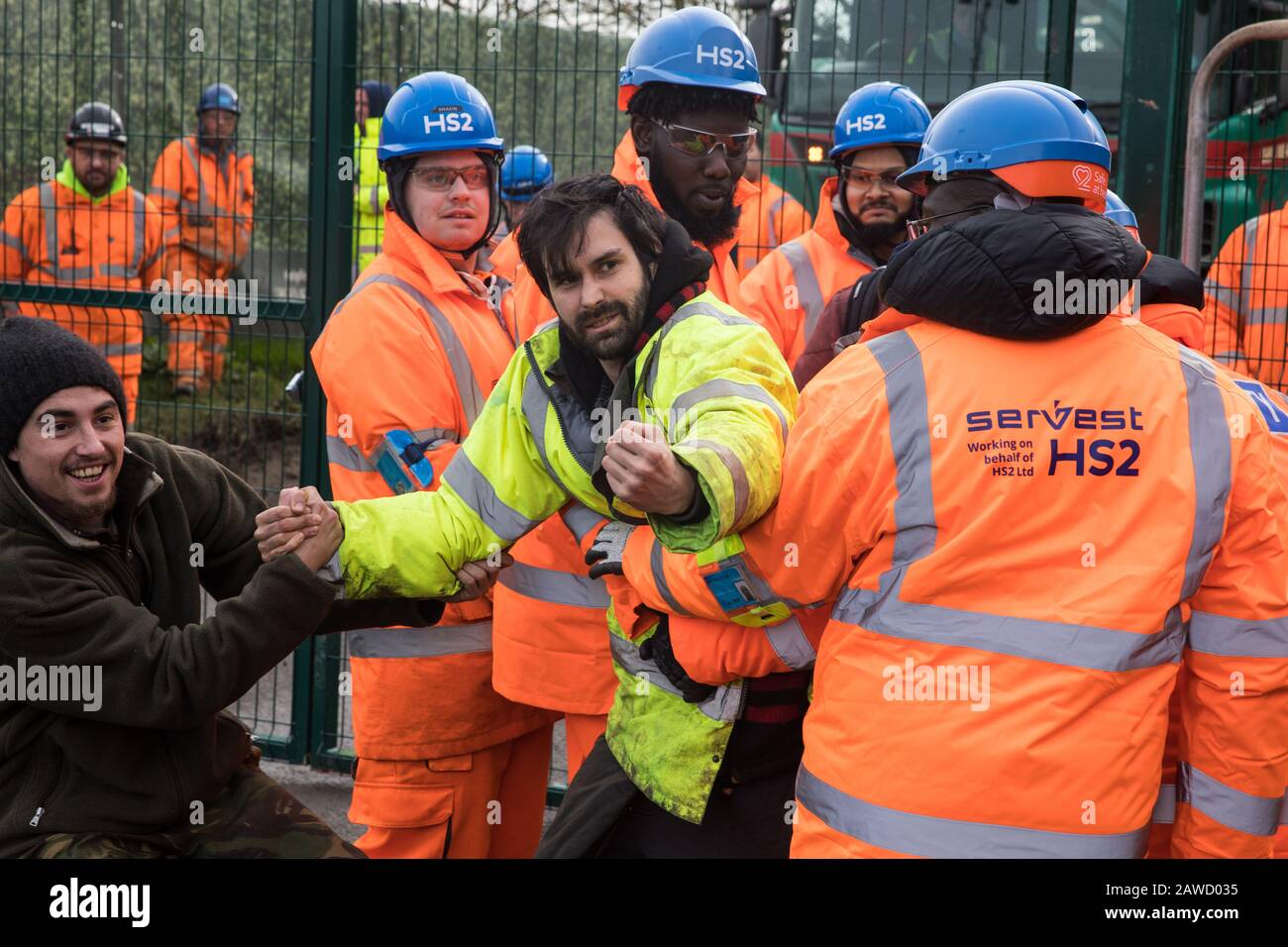 Harefield, UK. 8 February, 2020. HS2 engineers and security guards try to prevent environmental activists from Save the Colne Valley, Stop HS2 and Extinction Rebellion from accessing an area of Harvil Road fenced off in order to carry out tree felling works for the high-speed rail project. The activists were successful in preventing any of the scheduled tree felling by HS2 and after an intervention by a police officer all tree felling work has now been cancelled for the weekend. Credit: Mark Kerrison/Alamy Live News Stock Photo