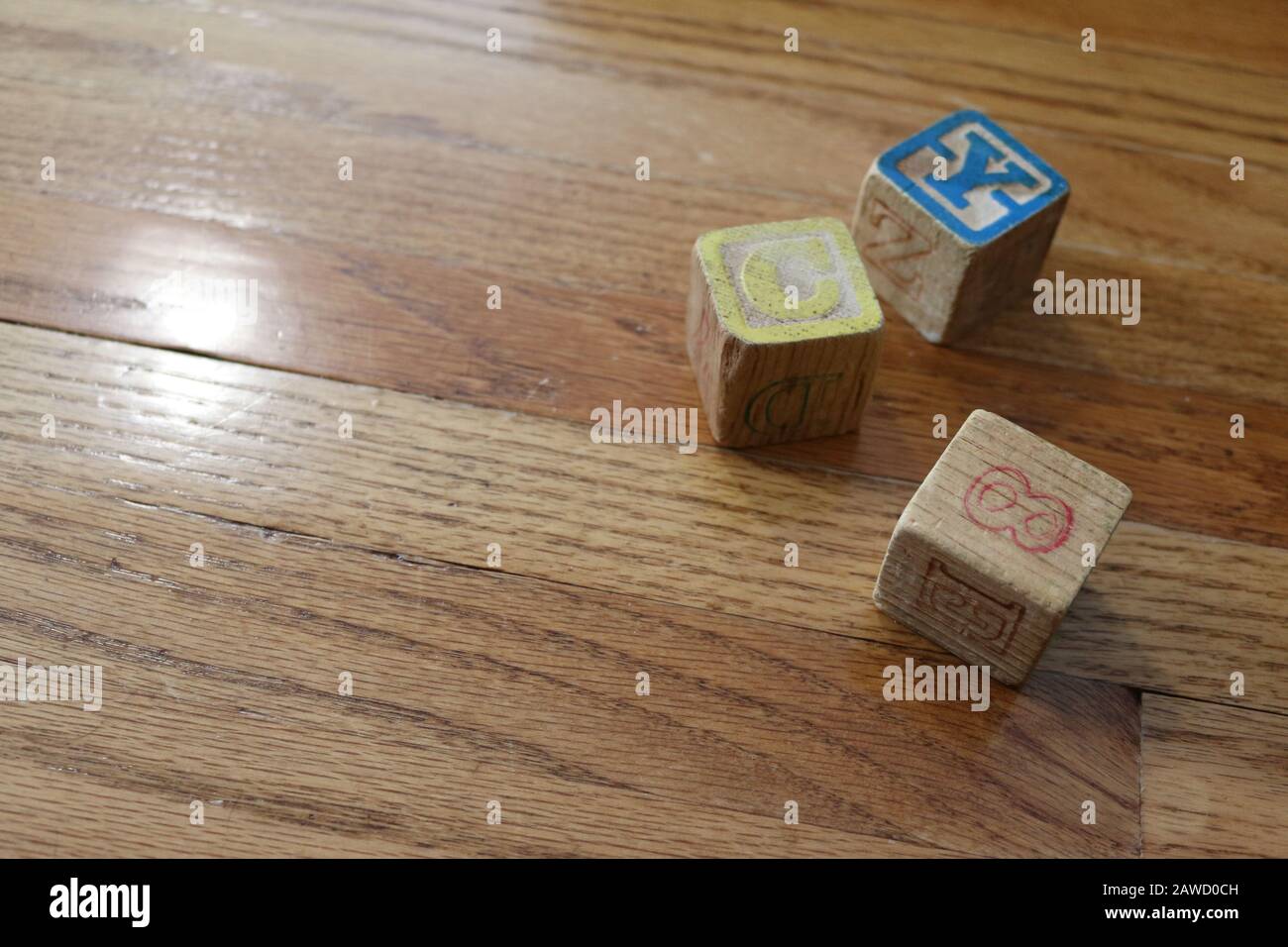 Three Old Wooden Colorful Alphabet Number Blocks on wood floor in natural light Stock Photo