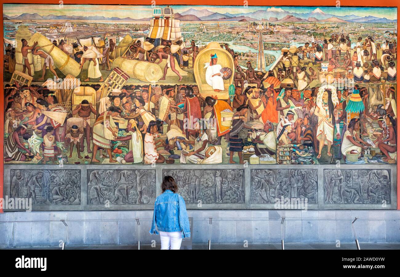 A tourist contemplates Diego Rivera's mural 'Tenochtitlan' at the National Palace in Mexico City. Stock Photo