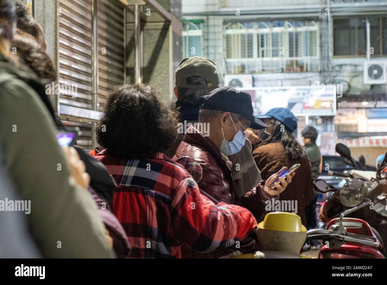 New Taipei City, Taiwan. 07th Feb, 2020. People in a queue to purchase face  masks outside a pharmacy in New Taipei.In response to the pneumonia  epidemic in Wuhan, masks rationing in Taiwan