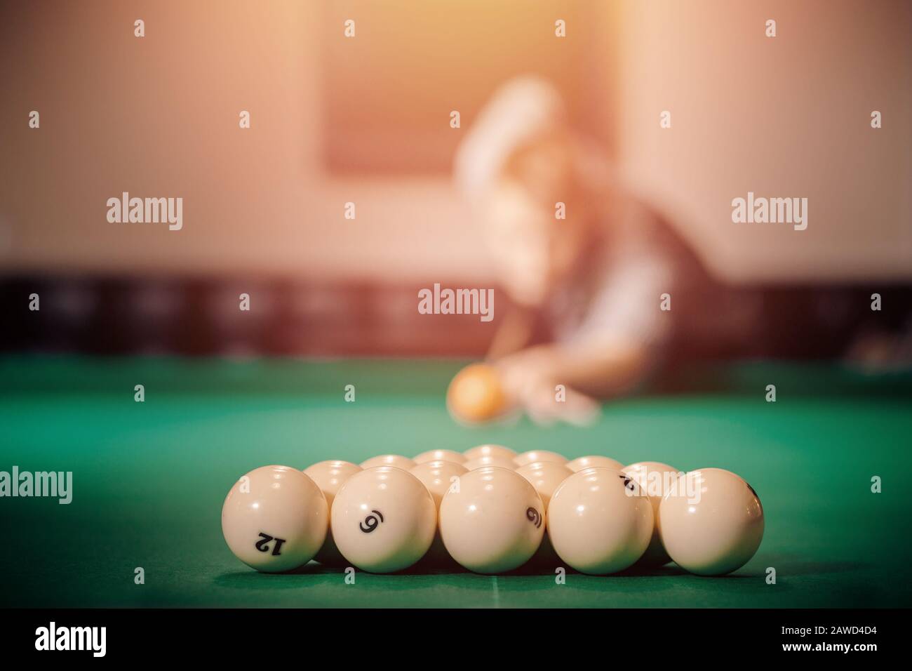 Man is player preparing and aiming to smash white balls in Russian billiards on green table. Stock Photo