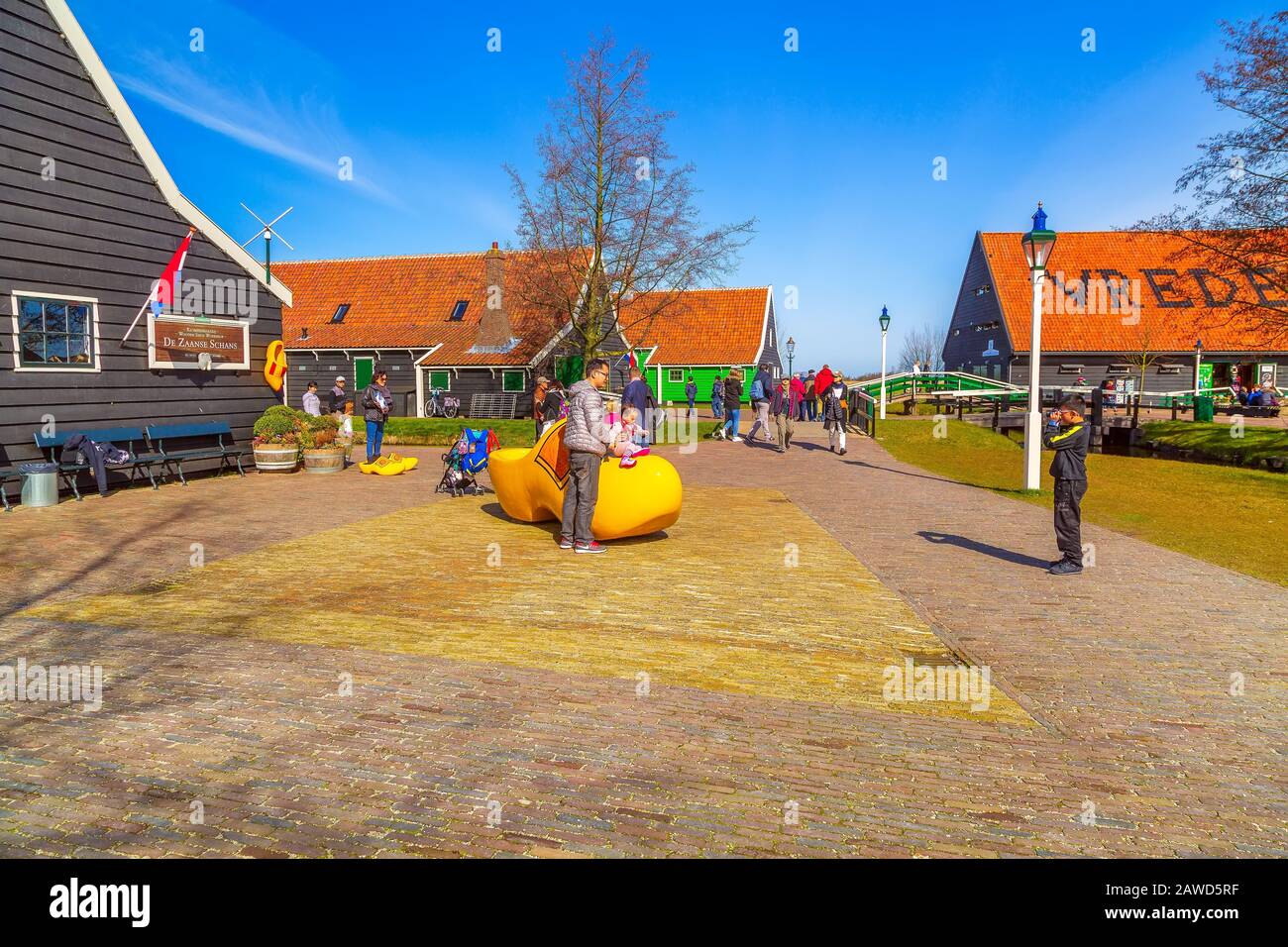 Zaanse schans, Netherlands - April 1, 2016: Large yellow wooden shoes, clogs or klompens for taking photo in Holland, people Stock Photo