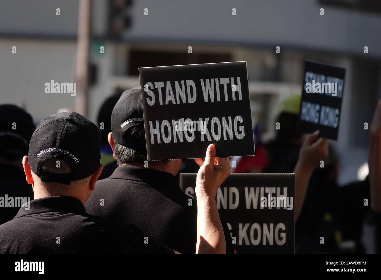 Nov. 24, 2019: Signs reading STAND WITH HONG KONG are shown being held by unidentified men wearing hats embroidered with CHINA DEMOCRACY PARTY. Stock Photo