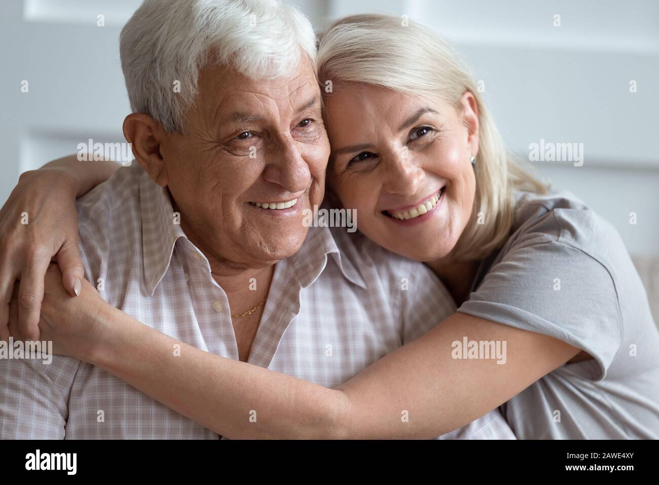 Headshot portrait of loving elderly couple hugging at home Stock Photo