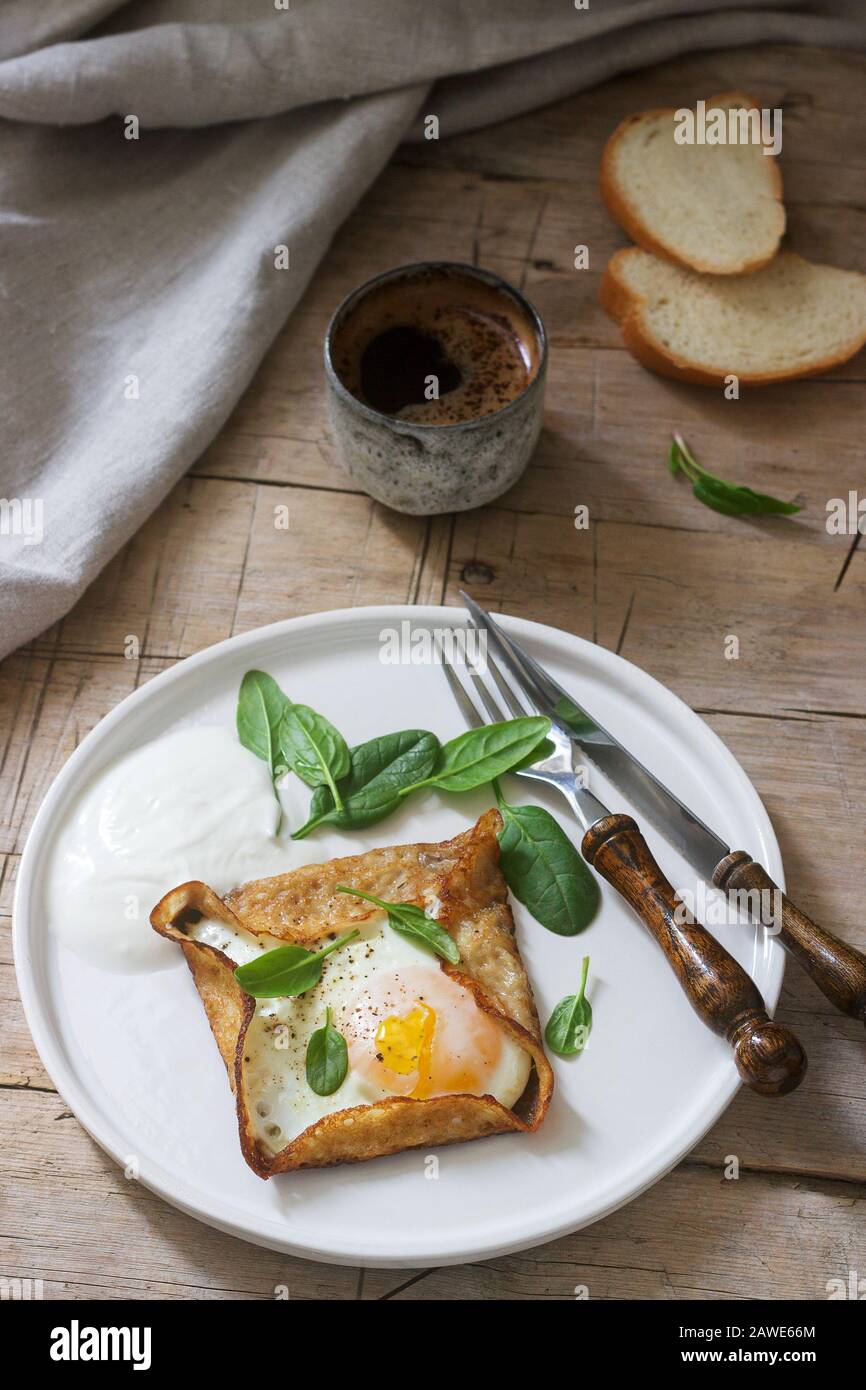 Breton buckwheat crepes with egg, spinach and cream, filed with the coffee. Rustic style Stock
