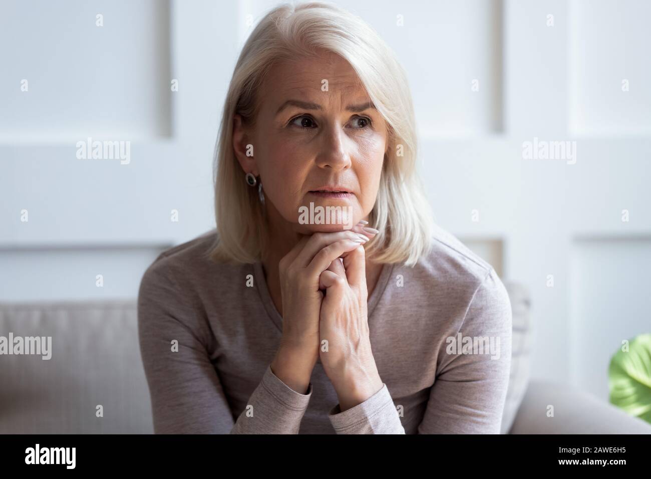 Sad senior woman look in distance thinking or mourning Stock Photo