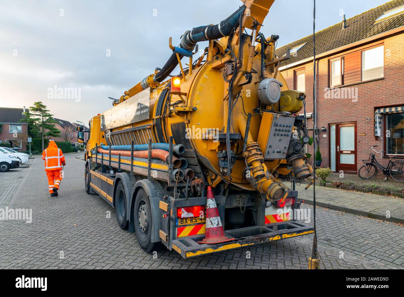 Workers with specialized truck cleaning sewer system in residential area Stock Photo