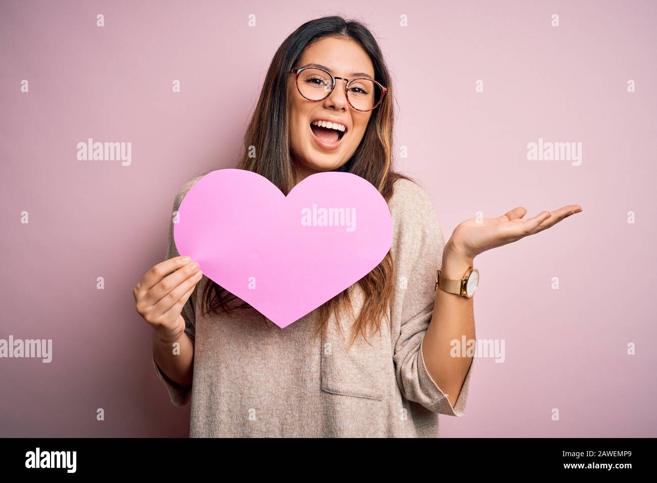 Young beautiful brunette romantic woman holding big heart paper ...