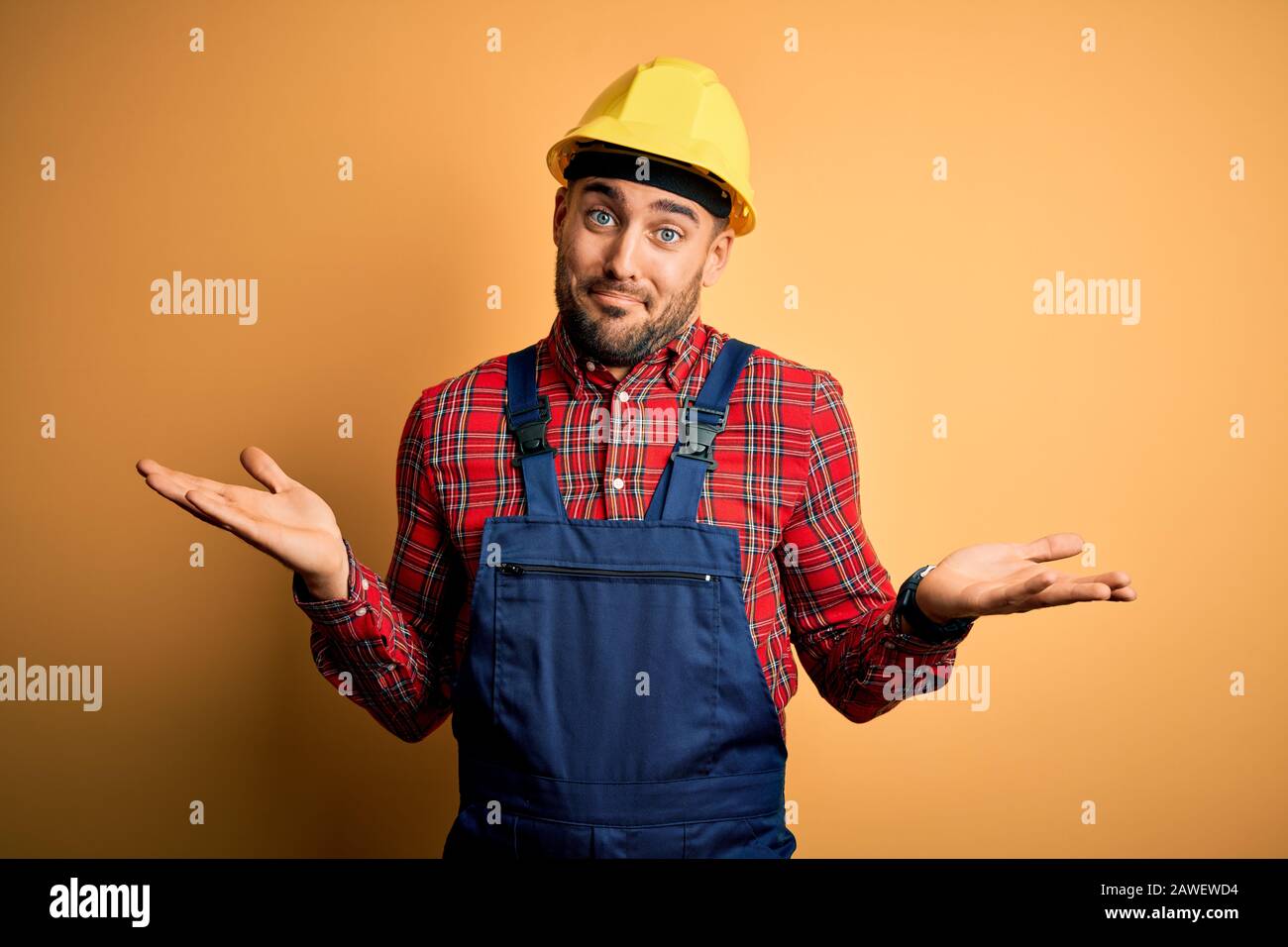 Young builder man wearing construction uniform and safety helmet over ...