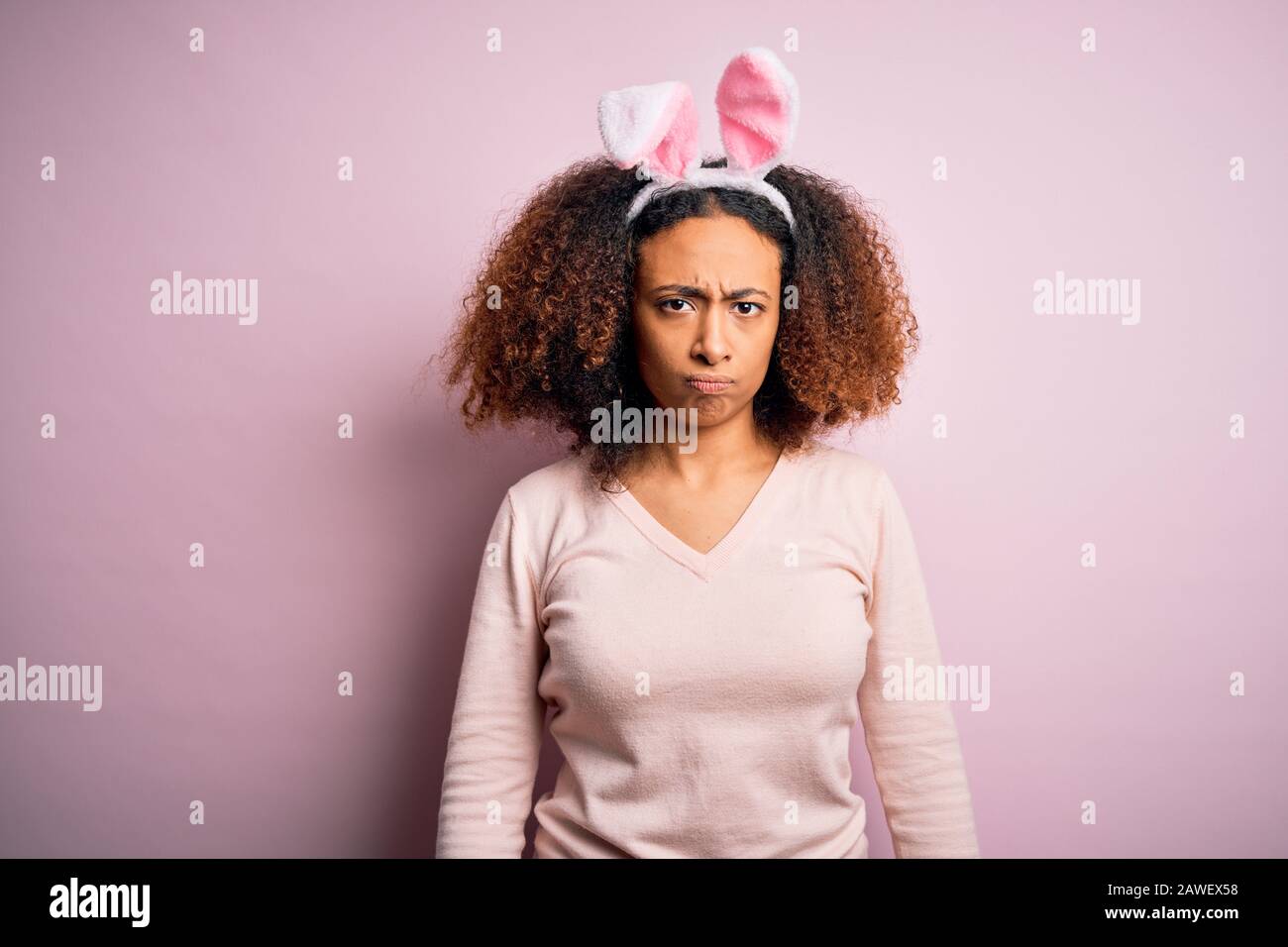 Young african american woman with afro hair wearing bunny ears over ...