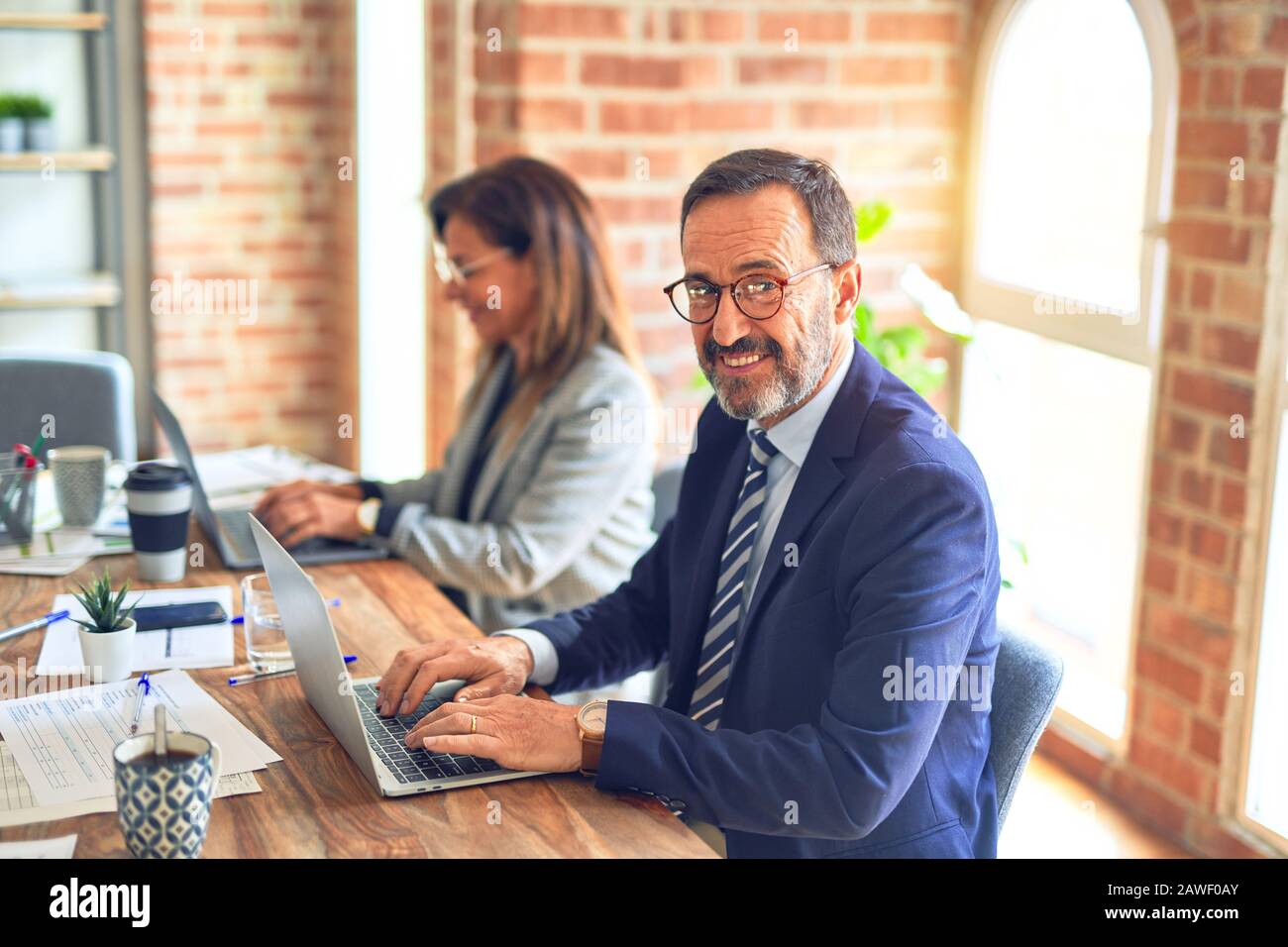 Two middle age business workers smiling happy and confident. Working ...