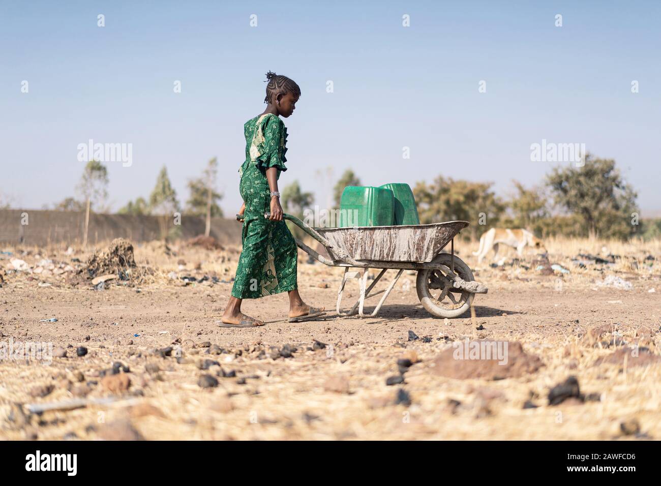 Young Black Offspring Collecting Tap Water in a natural environment Stock Photo