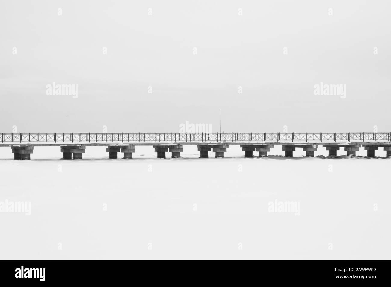 Bridge on the frozen lake. long footbridge dividing the horizon. conceptual minimalistic image. black and white background with copy space Stock Photo